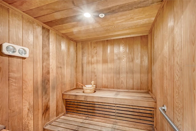 view of sauna with wooden ceiling and wood walls