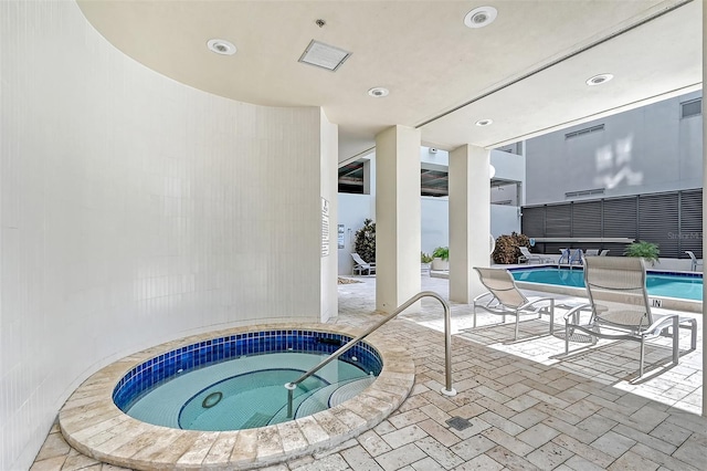 view of swimming pool featuring an indoor hot tub