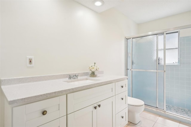 bathroom featuring walk in shower, vanity, toilet, and tile patterned floors