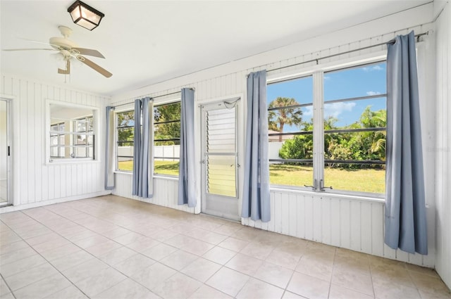 spare room with a healthy amount of sunlight, light tile patterned floors, and ceiling fan