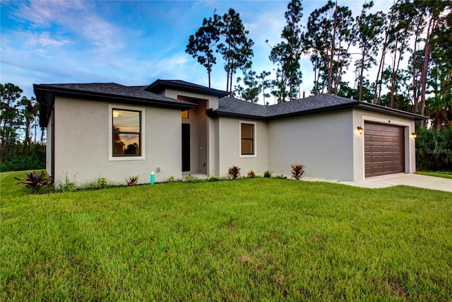 prairie-style home with a front yard and a garage