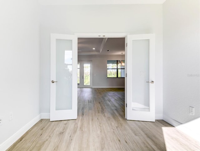 spare room featuring french doors and light hardwood / wood-style floors