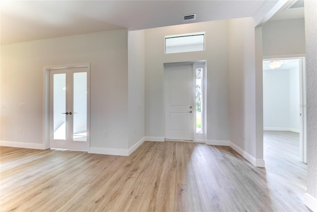 entrance foyer with light hardwood / wood-style floors and french doors