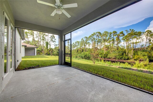 unfurnished sunroom with ceiling fan