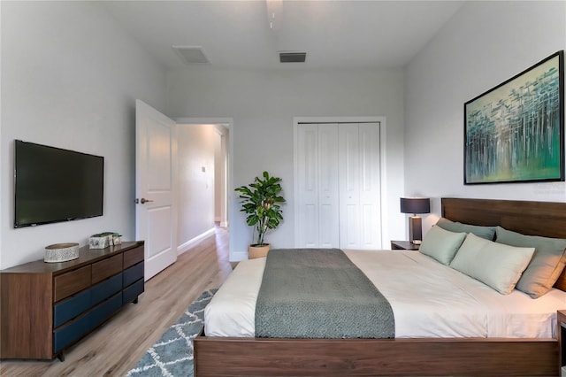 bedroom with ceiling fan, a closet, and light hardwood / wood-style floors