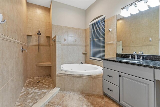 bathroom featuring tile patterned flooring, vanity, separate shower and tub, and tile walls