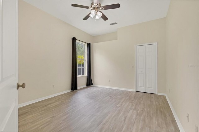 spare room with ceiling fan and light wood-type flooring