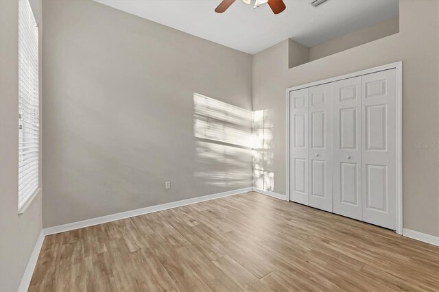 unfurnished bedroom with ceiling fan, a closet, and light hardwood / wood-style flooring