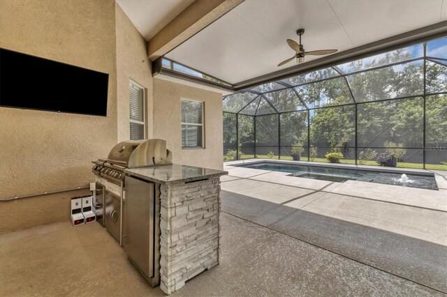 view of patio with glass enclosure, an outdoor bar, ceiling fan, and exterior kitchen