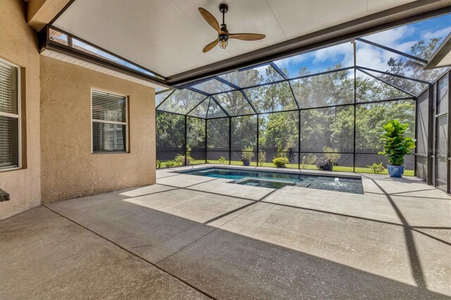 view of swimming pool with a patio, ceiling fan, and a lanai