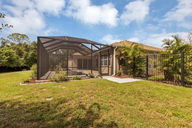 rear view of property with a lawn and glass enclosure