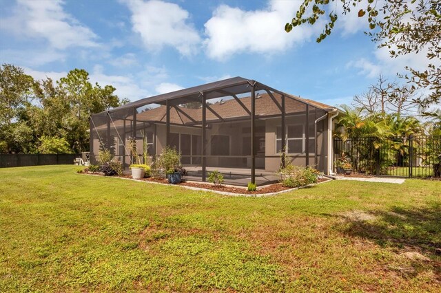 back of house featuring a yard and glass enclosure