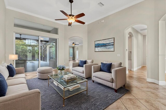 living room with ceiling fan, crown molding, and light tile patterned flooring