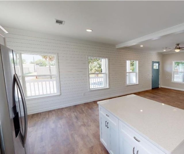 kitchen featuring white cabinets, ceiling fan, plenty of natural light, and stainless steel fridge