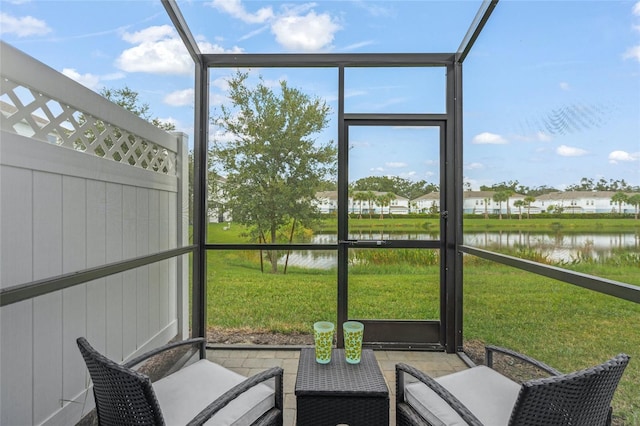 sunroom / solarium featuring a water view