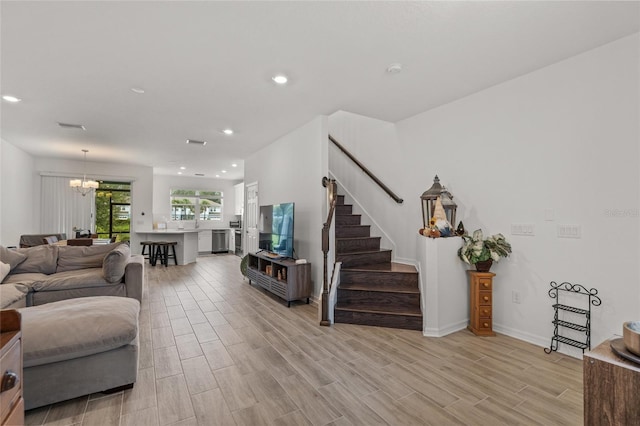 living room with an inviting chandelier and light wood-type flooring