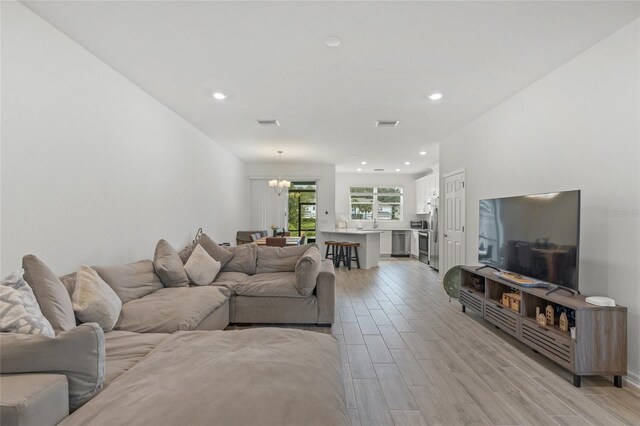 living room with light hardwood / wood-style flooring and a chandelier