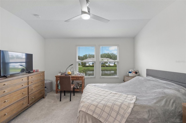 bedroom with ceiling fan, light colored carpet, and vaulted ceiling