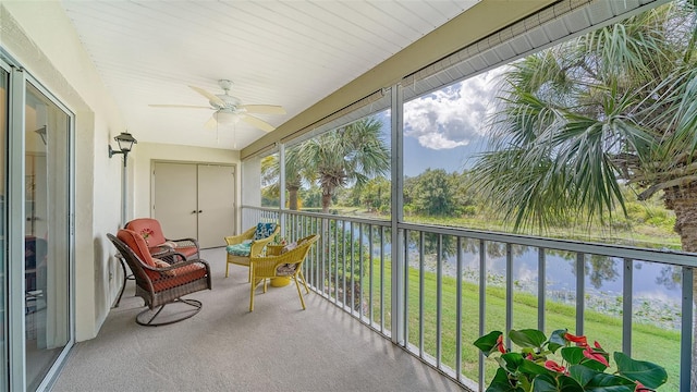 sunroom featuring ceiling fan, plenty of natural light, and a water view