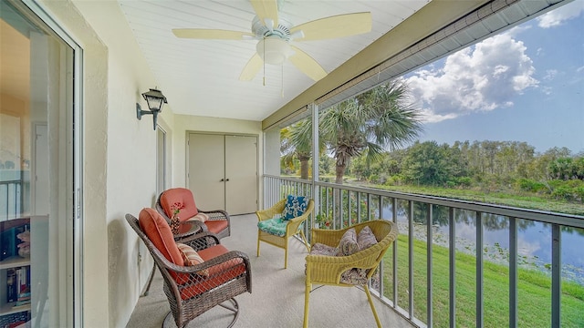 balcony with a water view and ceiling fan