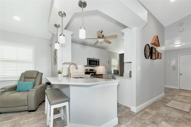 kitchen featuring sink, vaulted ceiling, white cabinetry, appliances with stainless steel finishes, and ceiling fan