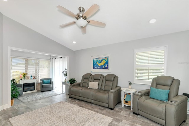 living room featuring light wood-type flooring, a healthy amount of sunlight, lofted ceiling, and ceiling fan