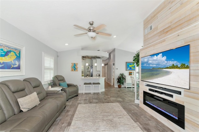 living room featuring wood-type flooring, vaulted ceiling, and ceiling fan