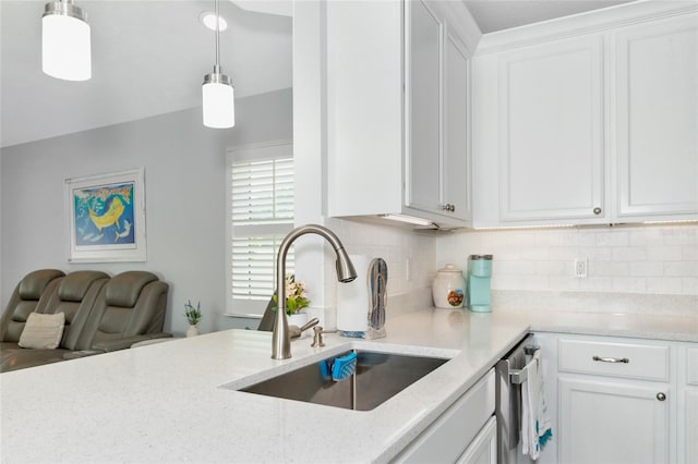 kitchen with white cabinets, decorative light fixtures, sink, and tasteful backsplash