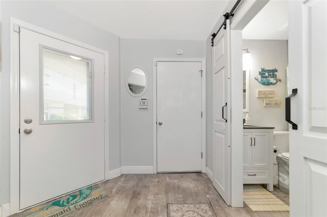 foyer with light hardwood / wood-style flooring and a barn door