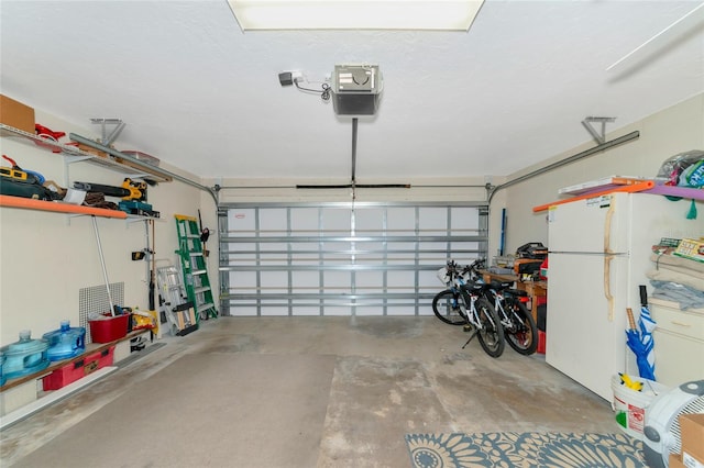 garage with a garage door opener and white fridge