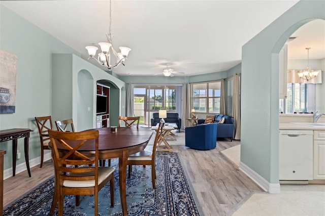 dining room featuring ceiling fan with notable chandelier and light wood-type flooring