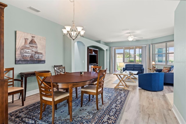 dining area featuring ceiling fan with notable chandelier and light hardwood / wood-style floors