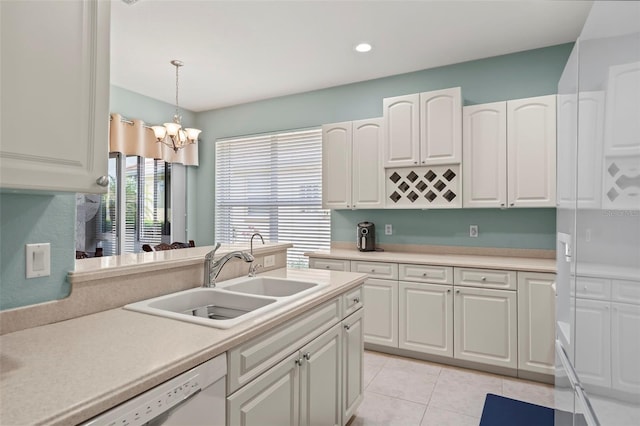 kitchen featuring light tile patterned flooring, white cabinets, decorative light fixtures, sink, and a chandelier