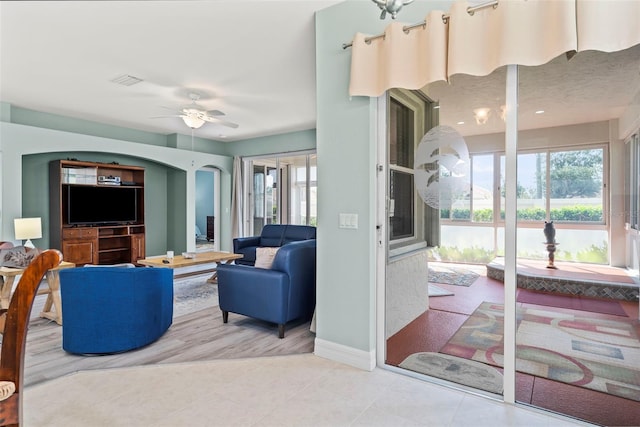 living room with ceiling fan and tile patterned floors