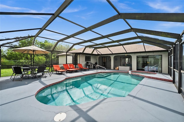 view of swimming pool featuring an in ground hot tub, glass enclosure, and a patio area