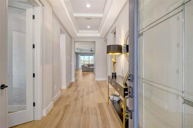 hallway featuring light hardwood / wood-style flooring and a tray ceiling