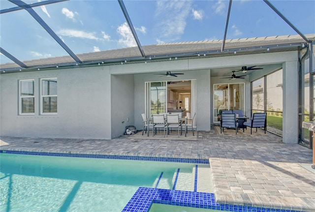 exterior space featuring a patio, glass enclosure, ceiling fan, and an outdoor hangout area