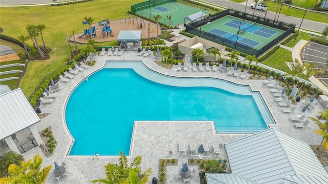 view of swimming pool featuring a patio and a yard