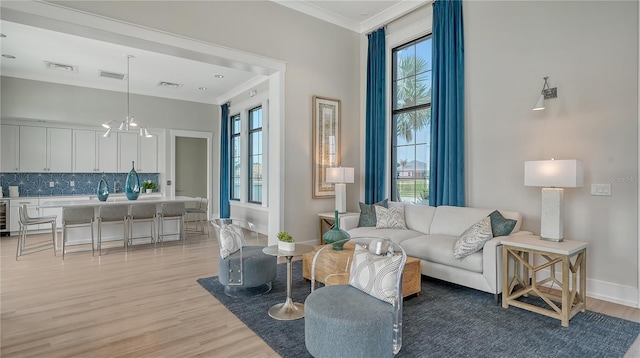 living room with light wood-type flooring, crown molding, and a wealth of natural light