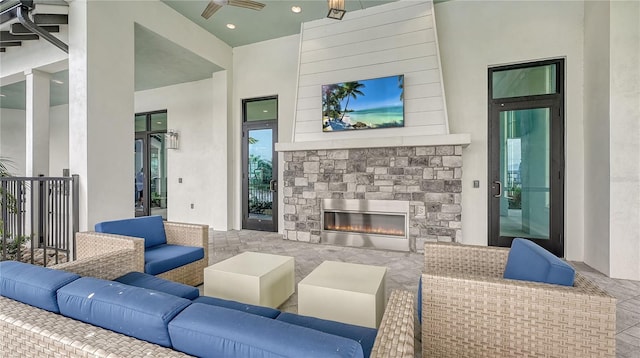 living room featuring a stone fireplace and a towering ceiling