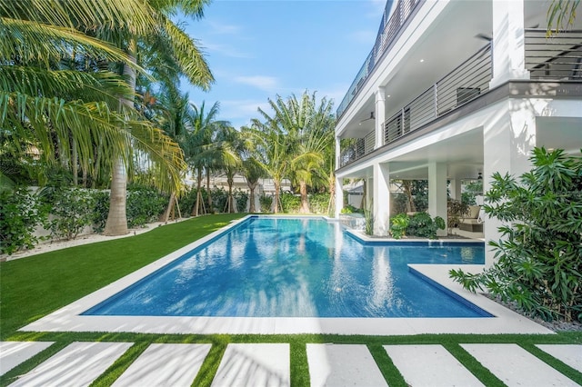 view of pool featuring a lawn