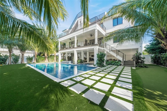 view of swimming pool featuring ceiling fan, a patio area, and a yard