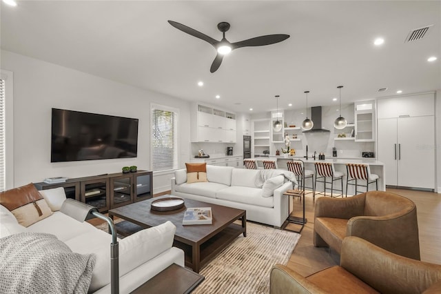 living room with light wood-type flooring and ceiling fan