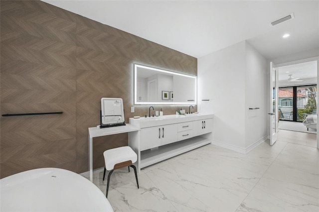 bathroom featuring backsplash, ceiling fan, a bathtub, and vanity