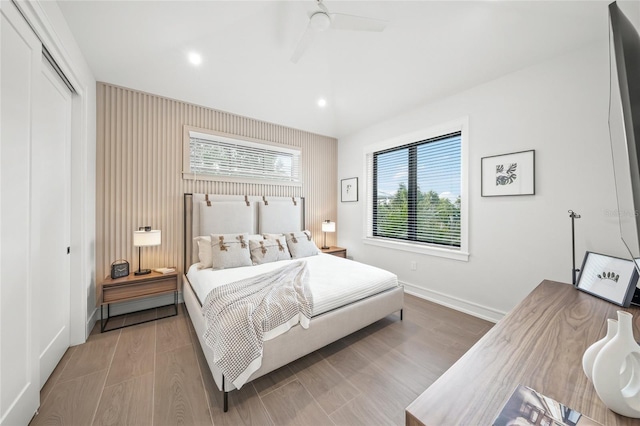 bedroom featuring hardwood / wood-style floors, ceiling fan, and a closet