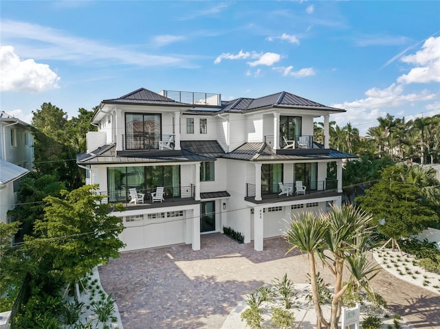 rear view of property featuring a garage and a balcony