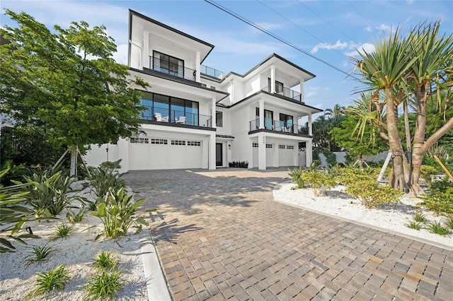 view of front of property featuring a balcony and a garage