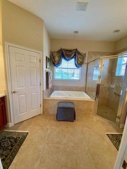 bathroom featuring vanity, plus walk in shower, plenty of natural light, and tile patterned floors