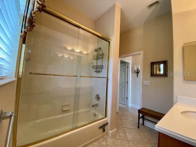 bathroom featuring vanity, tile patterned flooring, and combined bath / shower with glass door