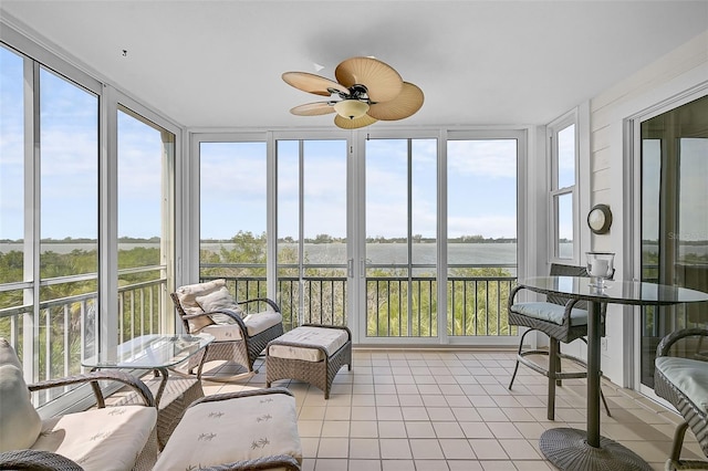 sunroom / solarium featuring a water view, ceiling fan, and plenty of natural light